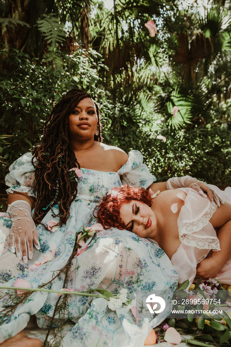 2 friends relax in the park together wearing dresses