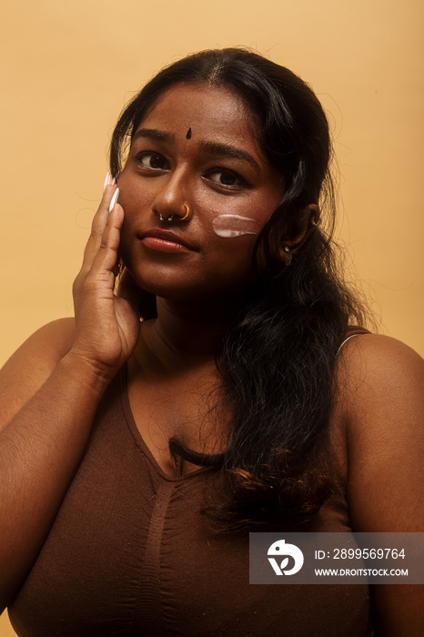 South Asian female solo lifestyle studio portrait skin care shot