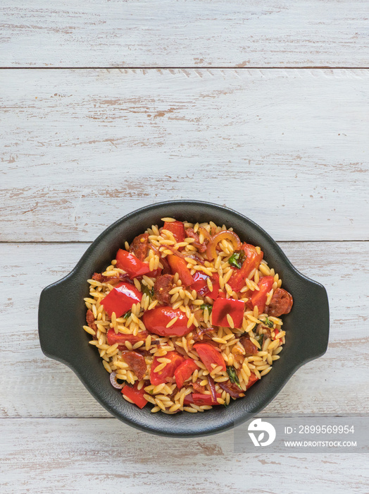 Chorizo orzo salad with roasted pepper, red onion and cherry tomatoes.