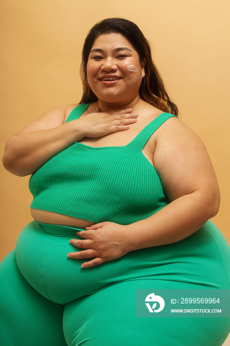 Plus size Asian female solo lifestyle studio portrait skin care shot