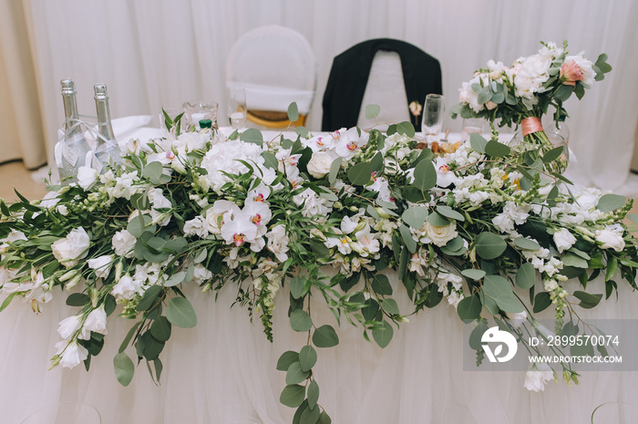 Wedding table for the newlyweds, decorated with fresh flowers and various decorations. Wedding, ceremony, party. Photography, concept.