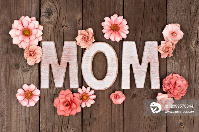 MOM wooden letters with paper flowers over a rustic wooden background