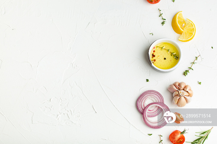 Food cooking background on white stone rustic table with fresh ingredients, vegetables, herbs, spices, olive oil from above with space for text