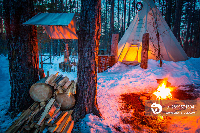Tipi. Indian hut. Wigwam. Yurt. Nomadic tribes. Northern people. Dwelling in the forest. Bonfire in the forest. Winter.