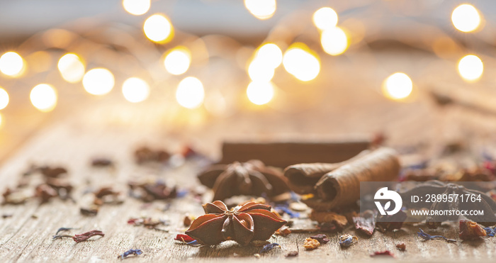 Its christmas time-christmas spices on wooden ground with lot of lights in the backround