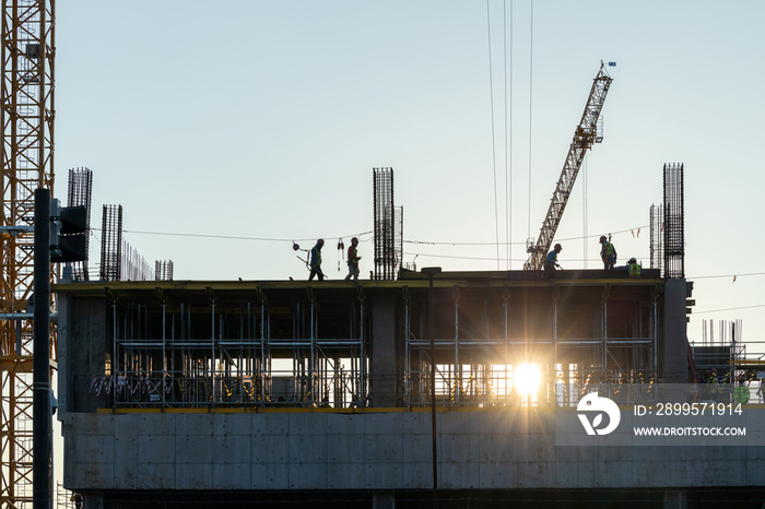 Builder workers working on construction site and sunset,beam, steel structure.Workers build large buildings on the construction site.Workers silhouette on contruction safty working.contruction concept