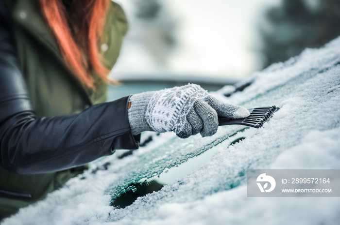 Removing snow from car windshield.  Clean car window in winter from snow.