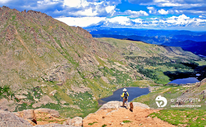 Hiker and dog on Colorado’s Mount Evans looking down at the Chicago Lakes.