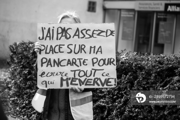 woman protesting in the streetwith placard in french : j’ai pas assez de place sur ma pancarte pour écrire tout ce qui m’énerve , in english, I don’t have enough space on my sign to write everything