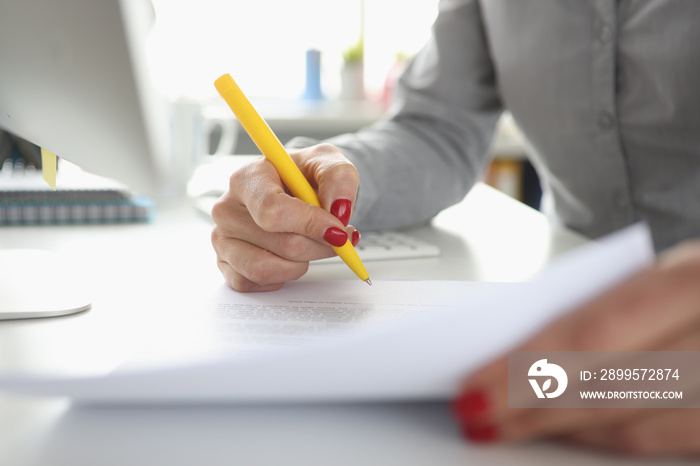 Woman hand holds pen and signs document