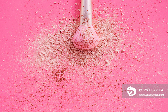 Make up brushes with powder on pink background