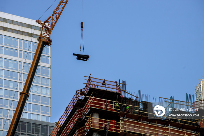 New York City building crane and buildings under construction against blue sky