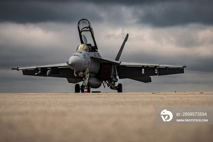 Jet fighter on the tarmac with storm clouds approaching