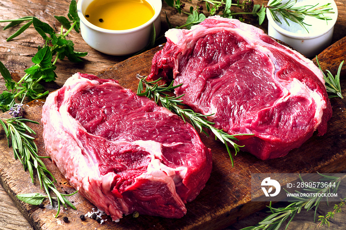 Raw meat Ribeye Steak with seasoning  on dark wooden background