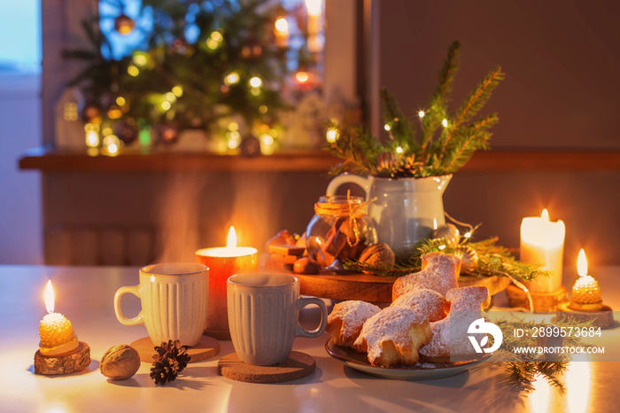 two cups of tea with homemade christmas baked goods on kitchen with christmas decoration