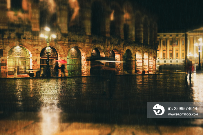 Old European night city lights and people walking blurred background