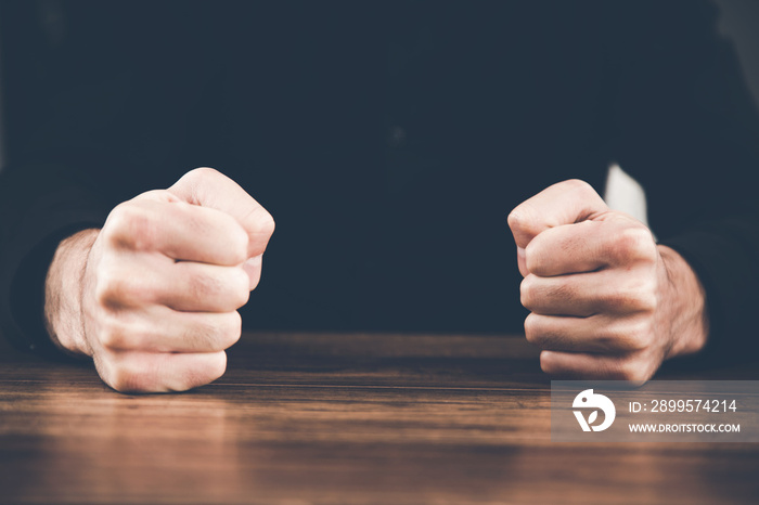 angry man fists on table