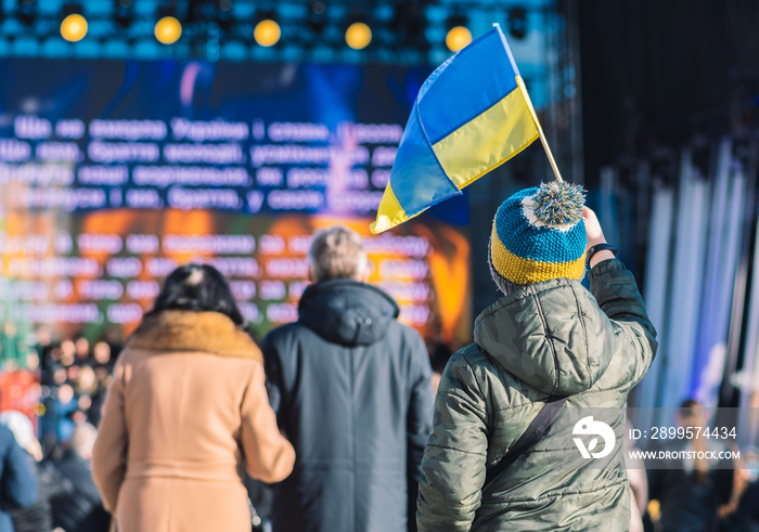 Child or kid with winter clothes and hat with Ukrainian colors. Protest against war in Ukraine