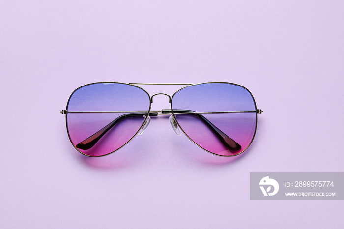 Stylish sunglasses on color background