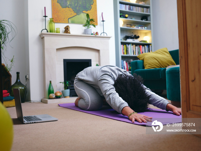 Woman practicing yoga at home