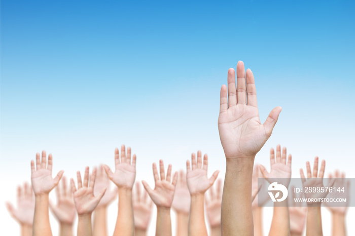 Business crowd raising hands high up on blue skies background. Concept Business / Question / Ask / Idea.