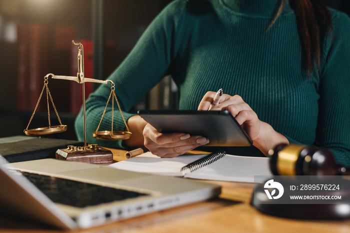 justice and law concept.Male judge in a courtroom  the gavel, working with smart phone and laptop and digital tablet computer on wood table in morning light