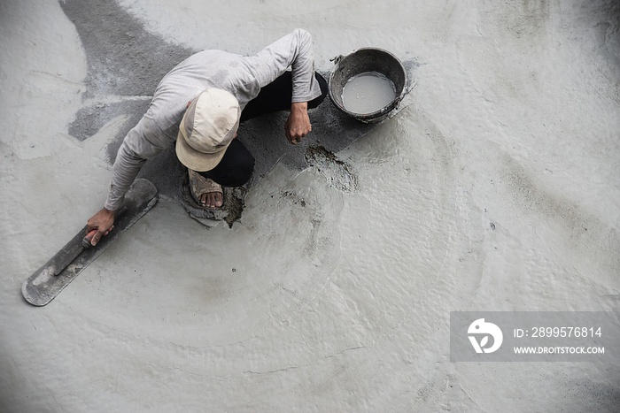 Construction man working with cement floor finishing - fresh concrete  work with construction hand tool concept