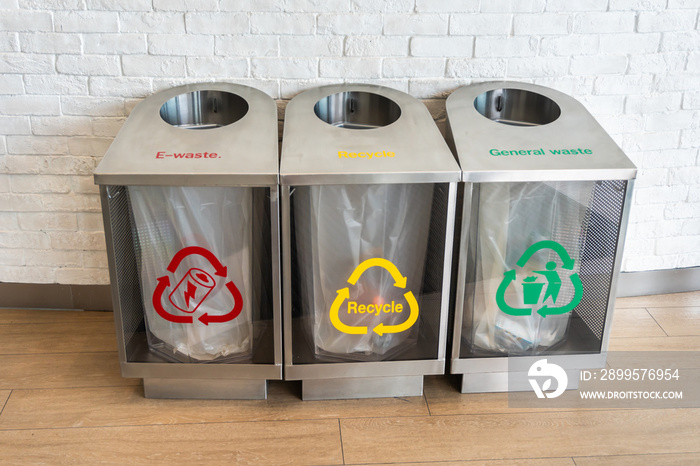 three modern waste bins Silver color for e-waste, recycle, general waste with red, yellow and green symbols