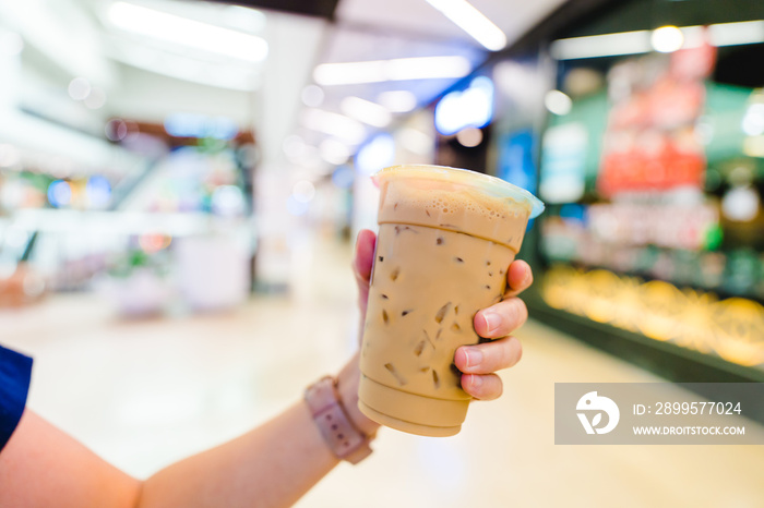 Woman holding Milk bubble tea in takeaway glass in Mall.A glass of takeaway bubble milk tea or boba tea.Fresh milk tea favorite beverage drink in Thailand, taiwan, Hong kong.Delivery online beverage.