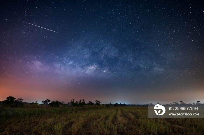 Milky way starry night sky  in the field and Perseid meteor shower before sunrise.