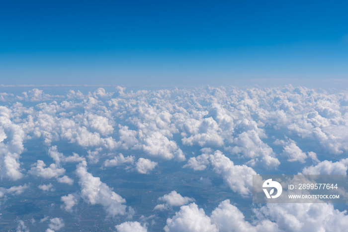 Blue sky and clouds, view from airplane window. Nature background, aerial view.