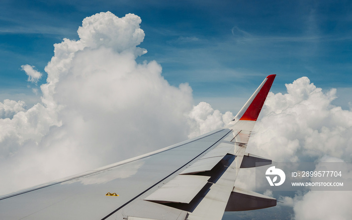 Flying and traveling. View of window at flying airplane, Plane wing on blue sky