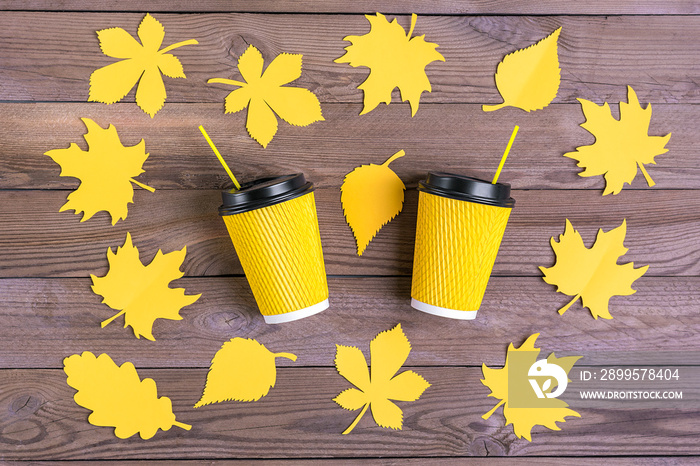 paper yellow cups of coffee and autumn leaves on wooden background First coffee, Hello autumn, september, october, november concept Top view Flat lay