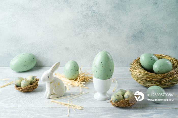 Easter holiday decorations with easter eggs, bunny and bird nest on wooden table