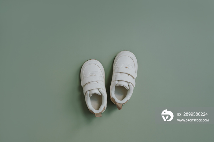 White sneaker shoes for child baby. Flat lay of nordic Scandinavian fashion children’s wearing. Aesthetic neutral pastel colour