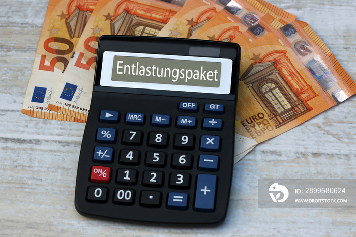 Taschenrechner mit dem Wort Entlastungspaket auf dem Display mit Eurobanknoten