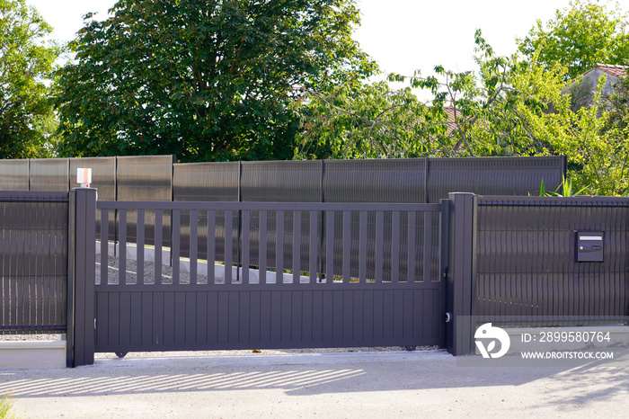 dark grey gate aluminum portal with blades suburbs house street