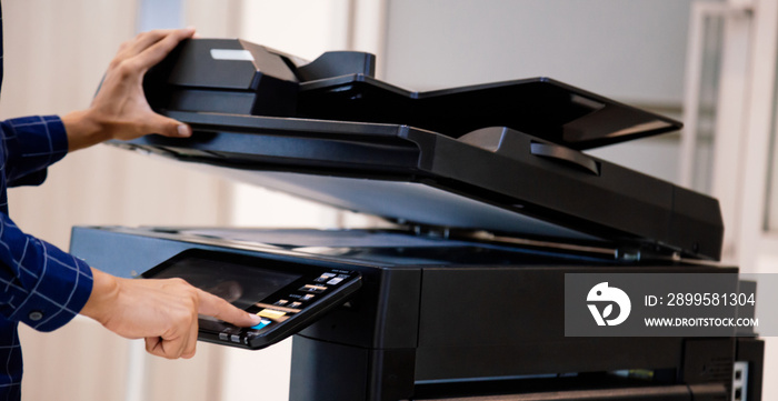 Businessmen press button on the panel for using photocopier or printer for printout and scanning document paper at office.