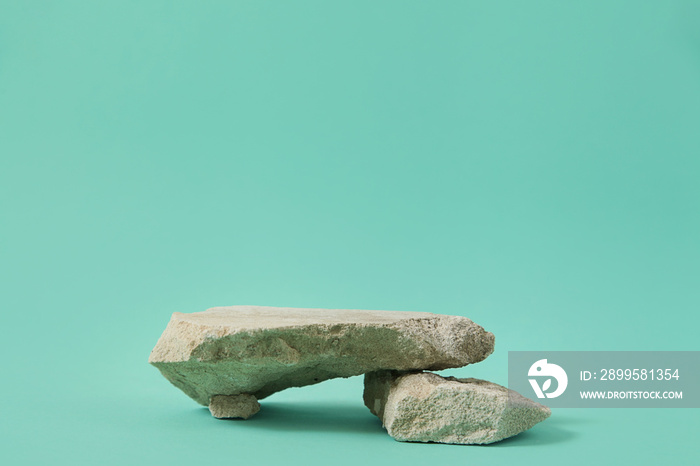 Podium natural stone, presentation of packaging, cosmetics on blue background.