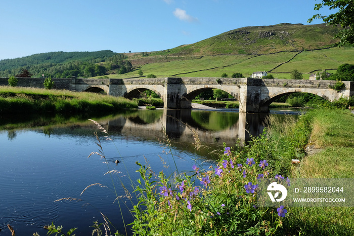 Burnsall Bridge over the River Wharfe toward Burnsall and Thorpe Fell, in the Yorkshire Dales, North Yorkshire.