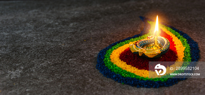 Close up clay lit light a fire already on Diya or oil lamp on concrete background, Decoration of Hinduism rangoli, Happy celebration Deepavali, or Diwali Indian festival concept