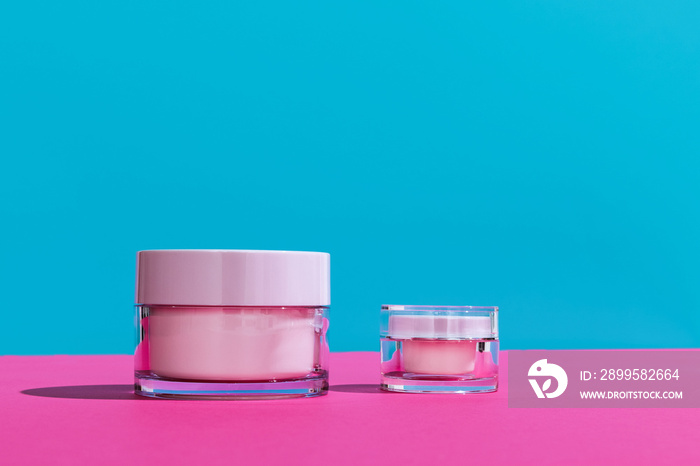 Jars of facial cosmetic cream with copy space for your brand isolated on bright colored background. Mockup