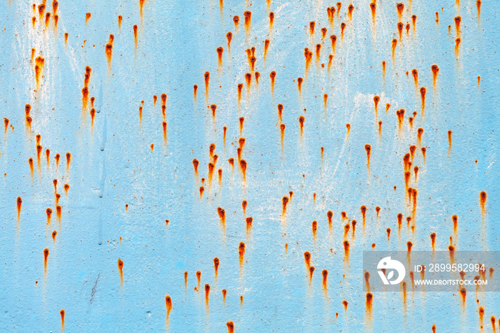 Old grungy blue metal wall with rust specks