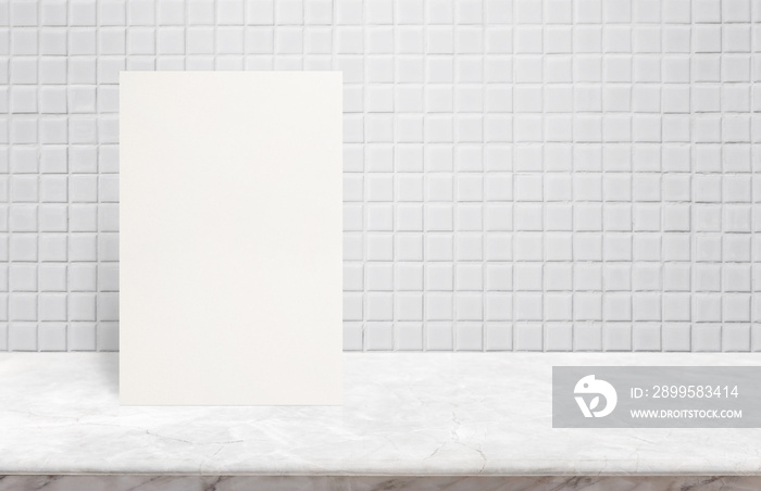 Blank White paper poster on marble stone table top at white mosaic ceramic tile wall,Template mock up for adding your design.