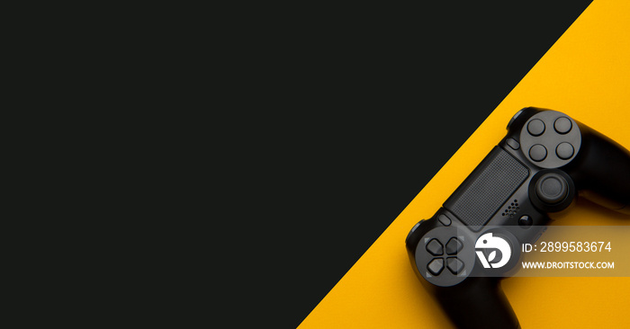 black wireless gamepad on a black and yellow background