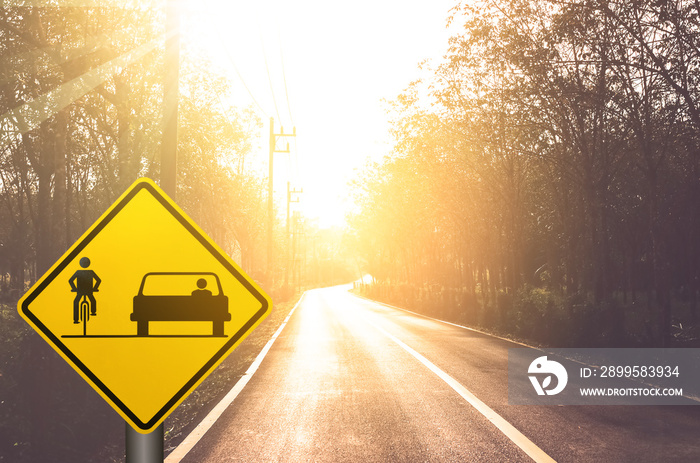 Bicycle and car share warning sign on blur traffic road with colorful bokeh light abstract background.