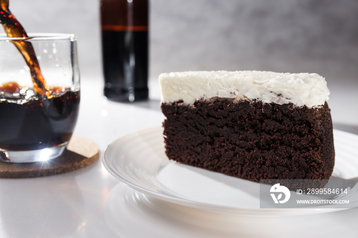 Portion of chocolate cake and black beer on white background with bottle