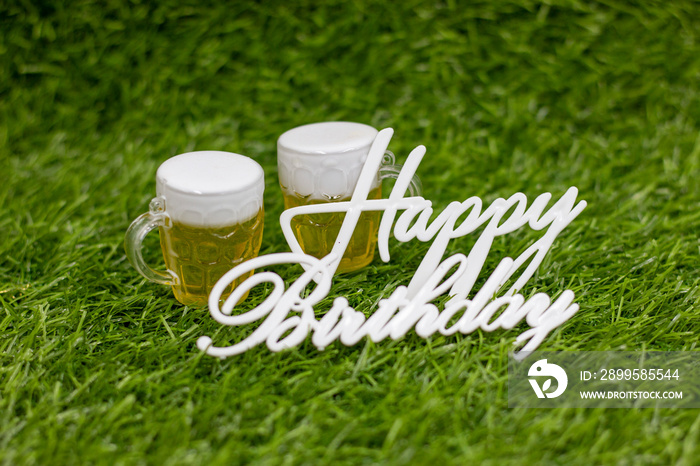 Happy Birthday with glasses of beer on green grass