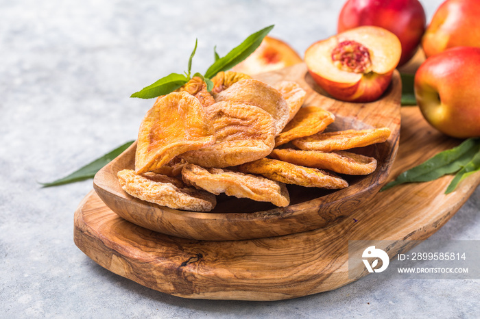 Dried fruits and Fresh peaches with leaves on stone background