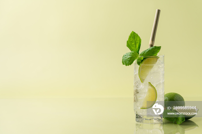 Refreshing lemonade with lime mint and ice. Pastel green background. Side view, copy space, minimal concept